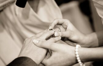 結婚式で相手の指に指輪をはめる二人