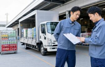 飲料配送車の前で配車表と勤務条件を比較する応募者と担当者