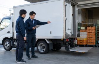配送センターでパン配送車の車格とテールゲートリフターの業務範囲を確認する応募者と指導員