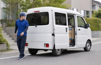 ECラストマイル配送のドライバーが軽貨物車の周囲を安全確認する