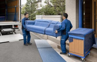 養生したソファを二人で搬入する家具配送スタッフ