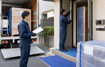 玄関の幅と養生を確認する家具配送スタッフ