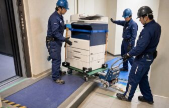 OA機器配送で複合機を台車と補助機器で搬入する作業員